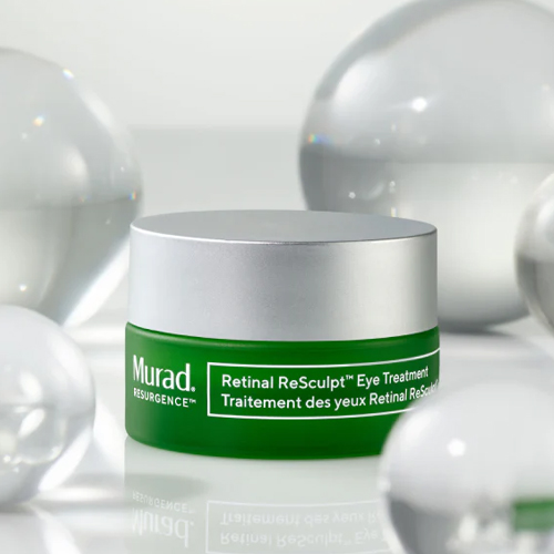 Groene potje van de Murad Retinal ReSculpt Eye Treatment omringd door glazen bollen