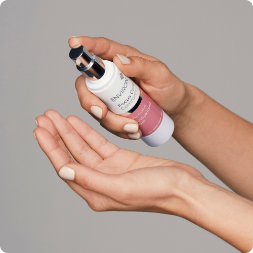 Close-up van een hand die de romige textuur van de Vita-Enriched Colostrum Gel aanbrengt op de huid.