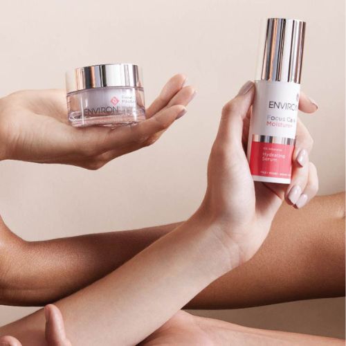 Sfeerbeeld van twee armen die elk een Environ Moisture+ product vasthouden: de Vita-Antioxidant Hydrating Oil Capsules pot en het HA Intensive Hydrating Serum.