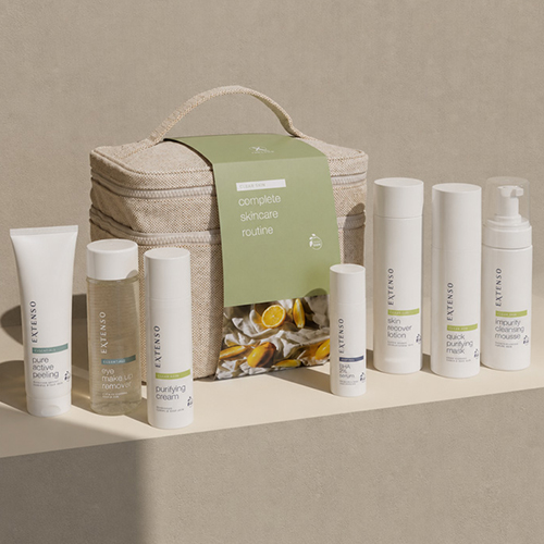 Extenso complete skincare routine clear skin set met een groene wikkel om een beige tas omringd door reinigingsmousse peeling en purifying cream