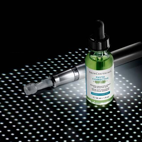SkinCeuticals Phyto Corrective serum flesje naast een microneedling apparaat op een verlicht oppervlak