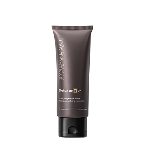 Een studio productfoto van een staande bruingrijze tube Synergie Skin Detox anTi ox purifying detox mask van 100ml met een zwarte klikdop tegen een witte achtergrond.