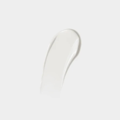 Textuur swatch van een zachte, romige witte crème op een egale grijswitte achtergrond