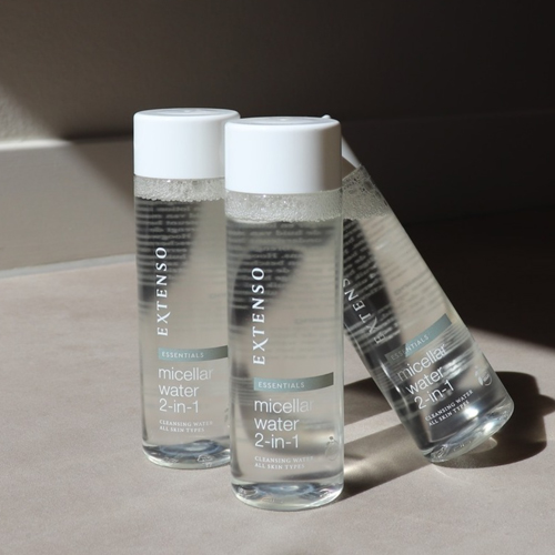 Drie flessen Extenso micellair water die bij elkaar staan op een lichtgrijze ondergrond met schaduwwerking